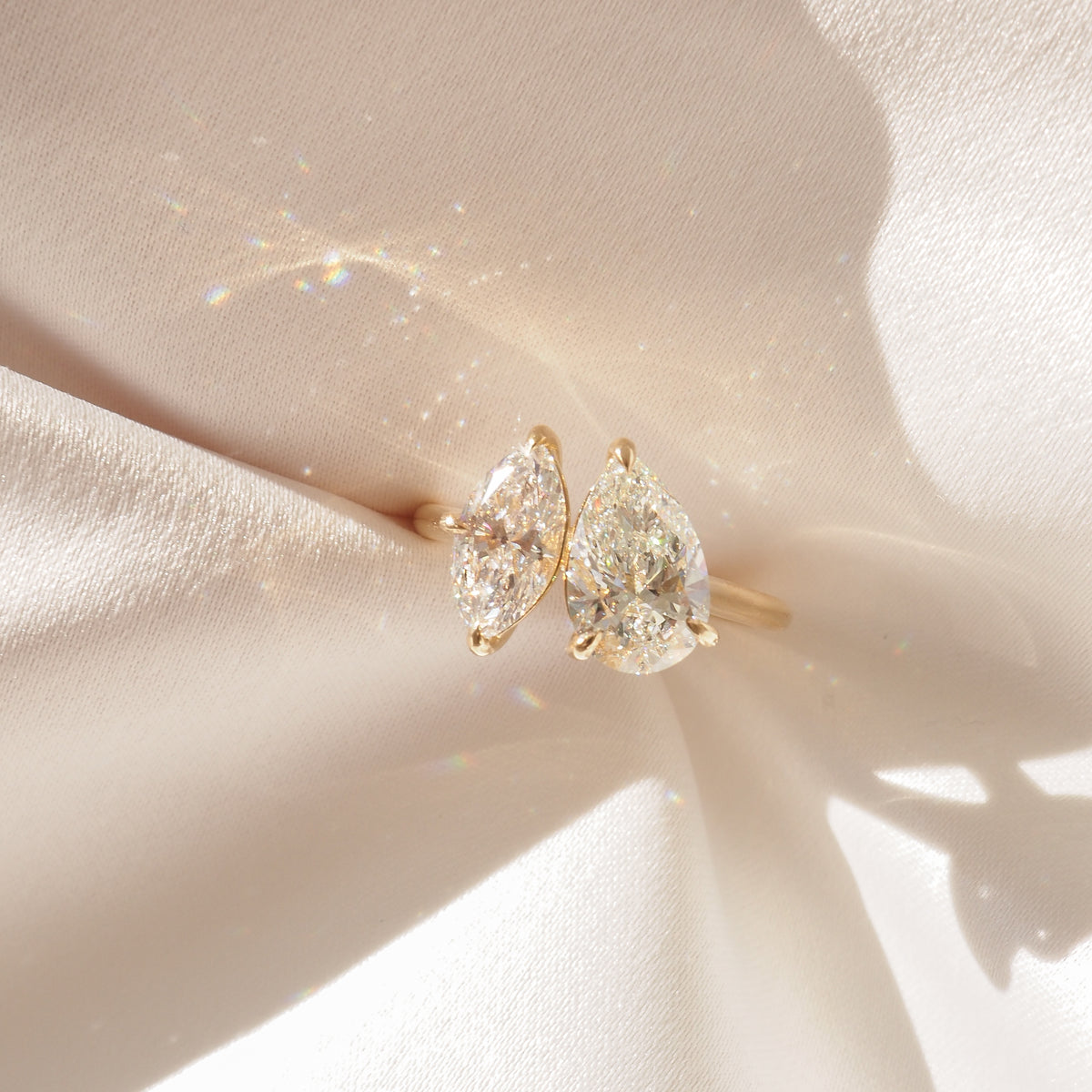 Pear and marquise lab-grown diamond engagement ring, two-stone close-up in yellow gold