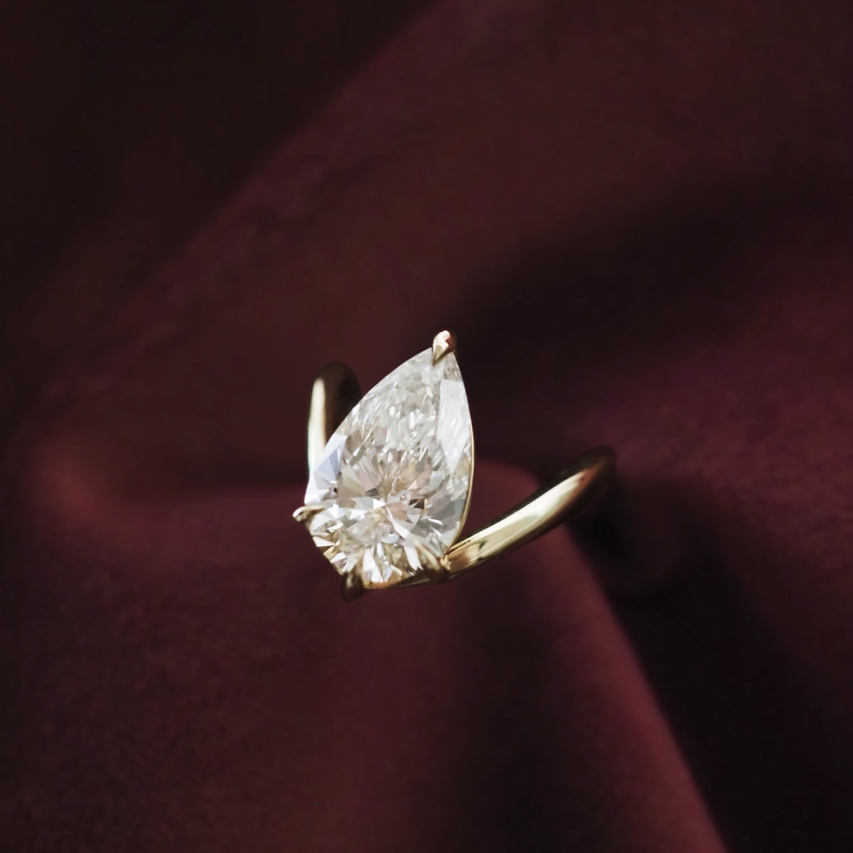 Gold ring with pear-cut solitaire diamond, tapered band detail