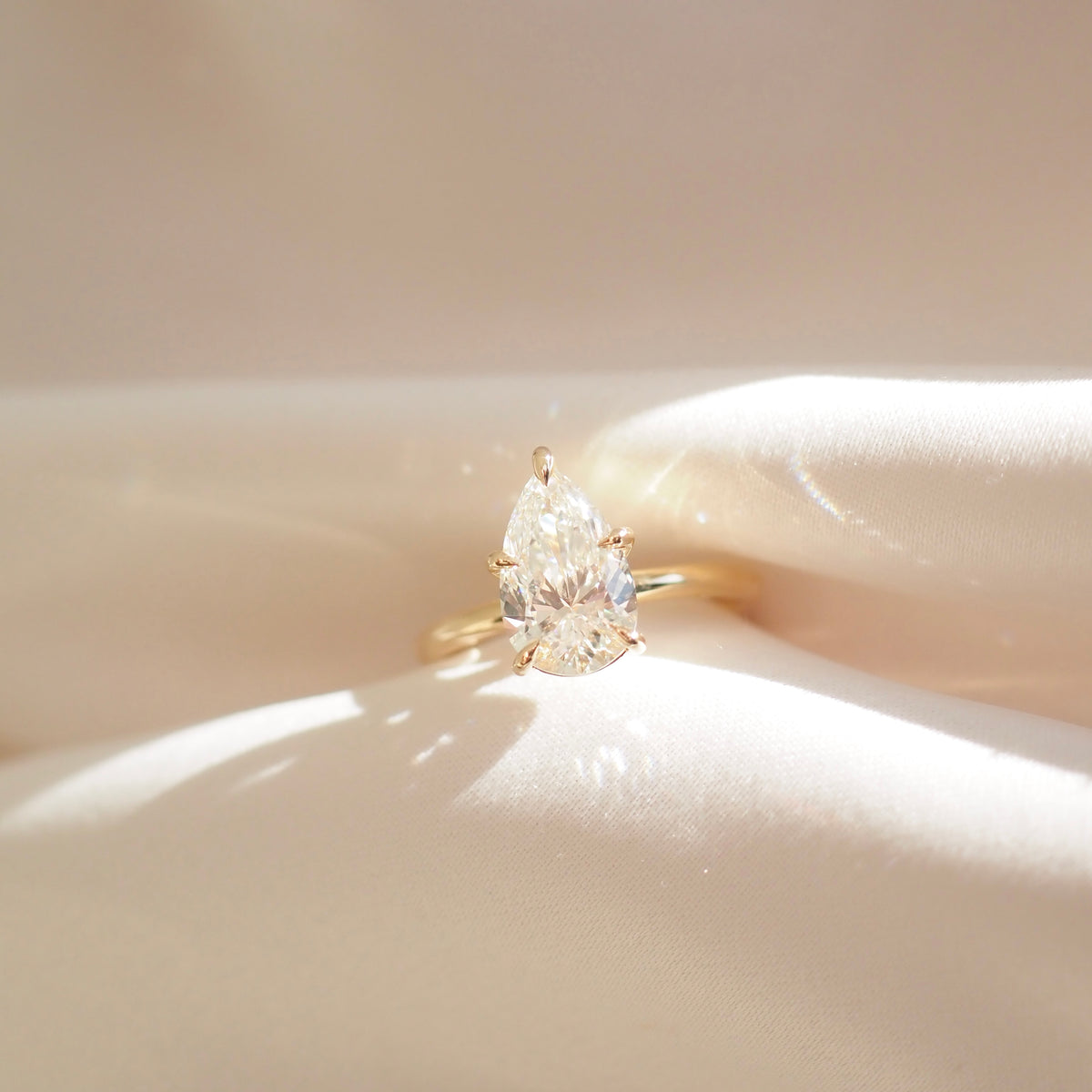 Pear-shaped diamond solitaire engagement ring with gold band