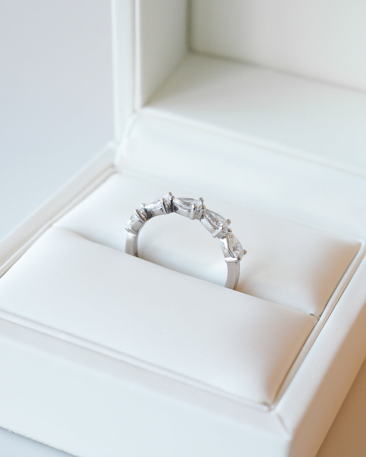White gold diamond wedding ring with pear-shaped stones, shown in gift box