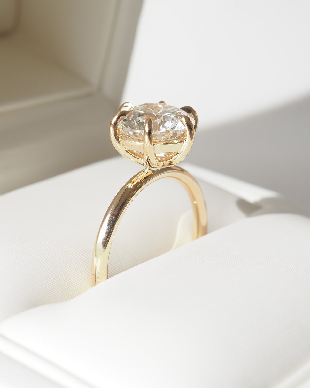 Round solitaire engagement ring, yellow gold band with diamond in prong setting