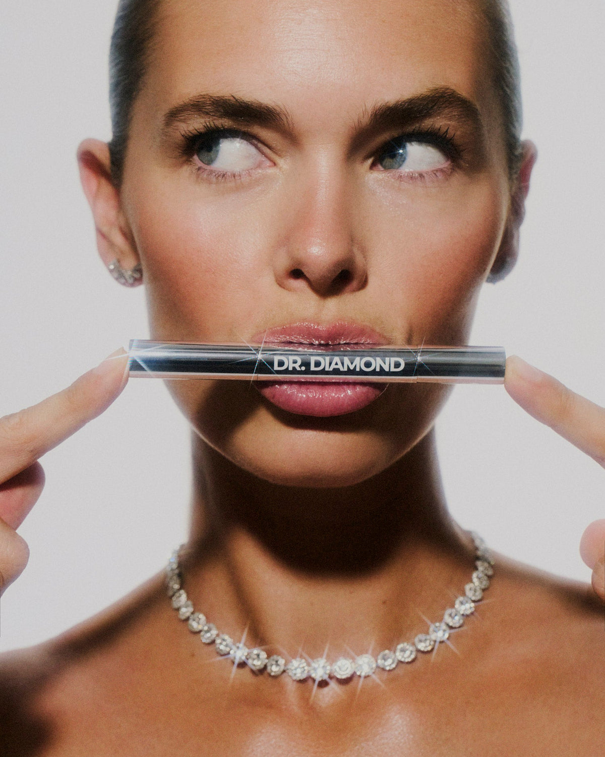 Dr. Diamond cleaning pen held over diamond necklace