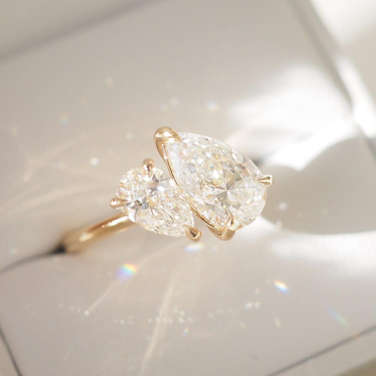 Yellow gold pear-cut lab diamond engagement ring, side view with two stones