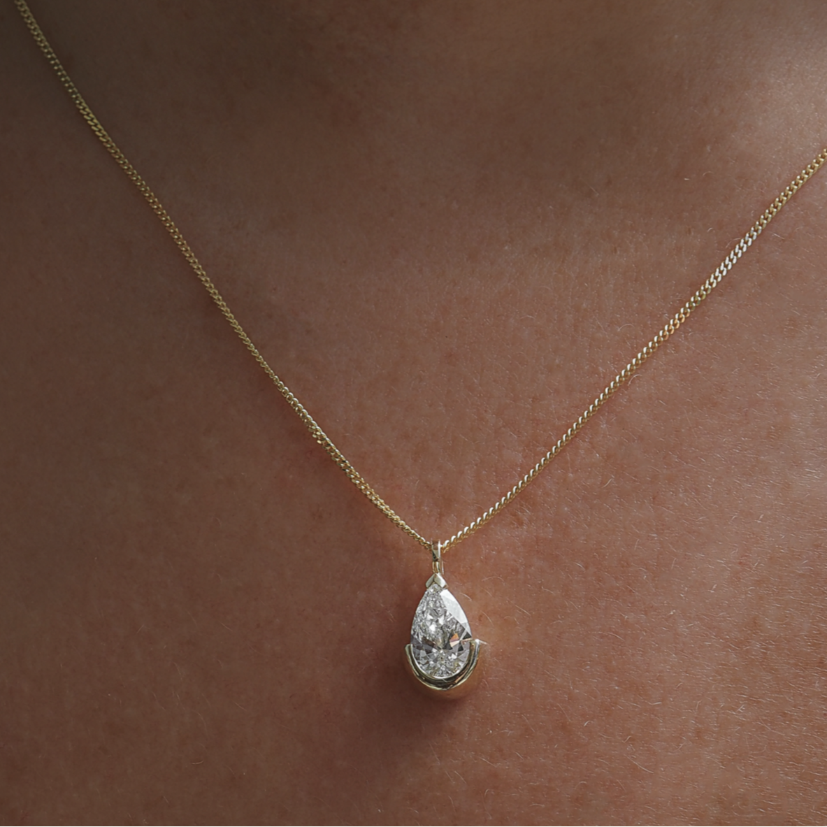 Yellow gold chain necklace with pear-shaped floating diamond pendant