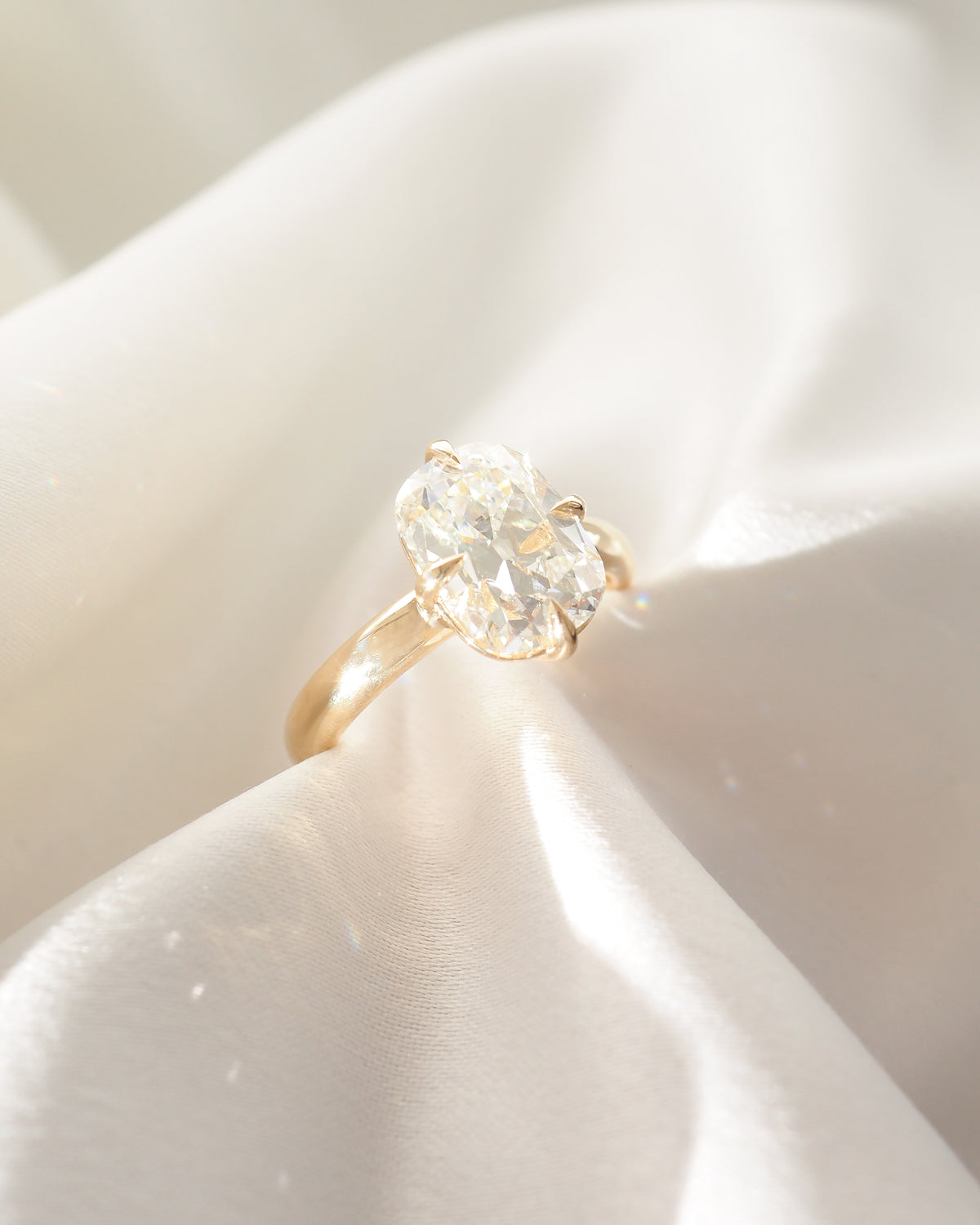 Yellow gold cushion-cut lab-grown diamond solitaire ring, close-up on prongs