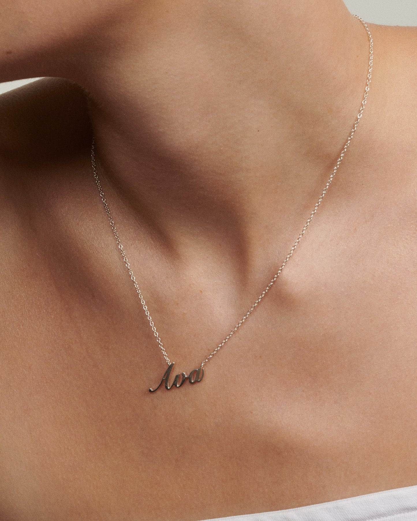 Necklace with 'ava' pendant on a person's neck