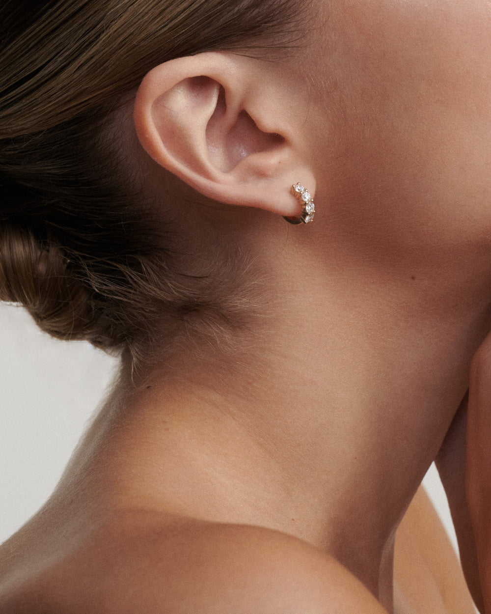 Close-up of a woman wearing a diamond earring.