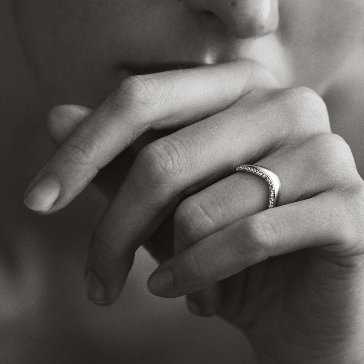 Close-up of a hand with a ring on a blurred background