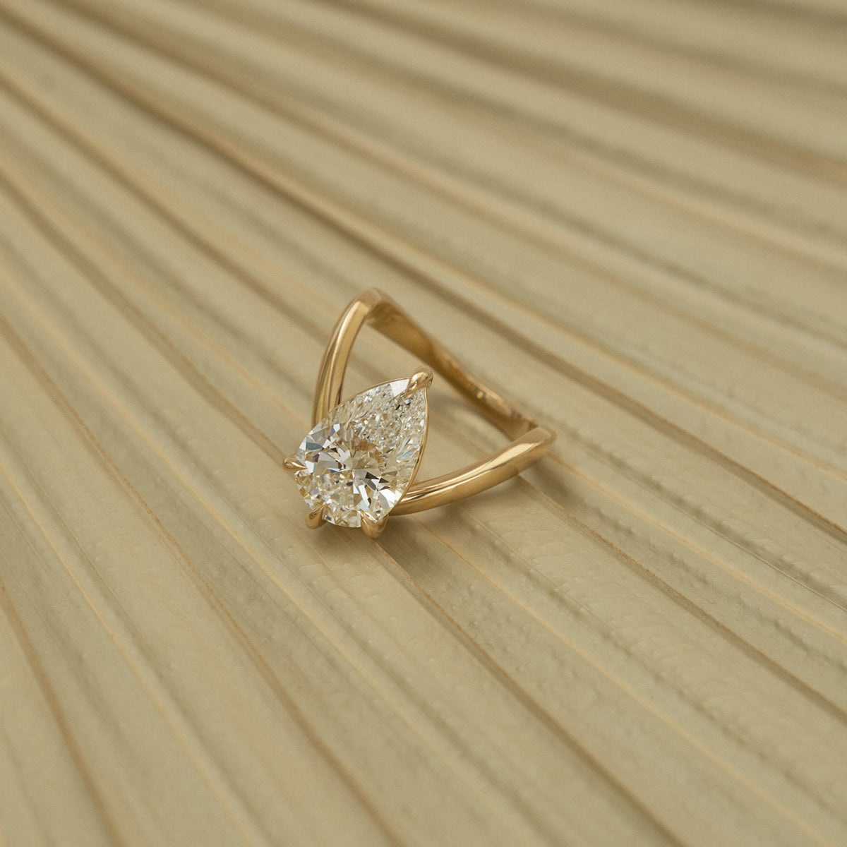 Yellow gold ring with pear-cut solitaire diamond, split band