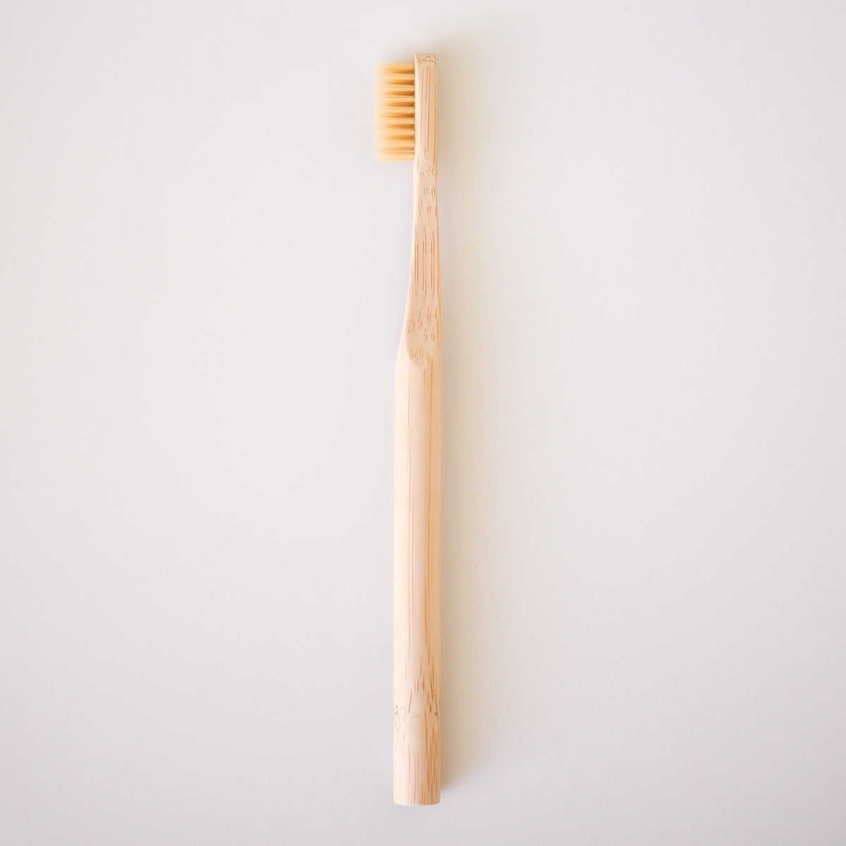 Bamboo toothbrush on a light gray background
