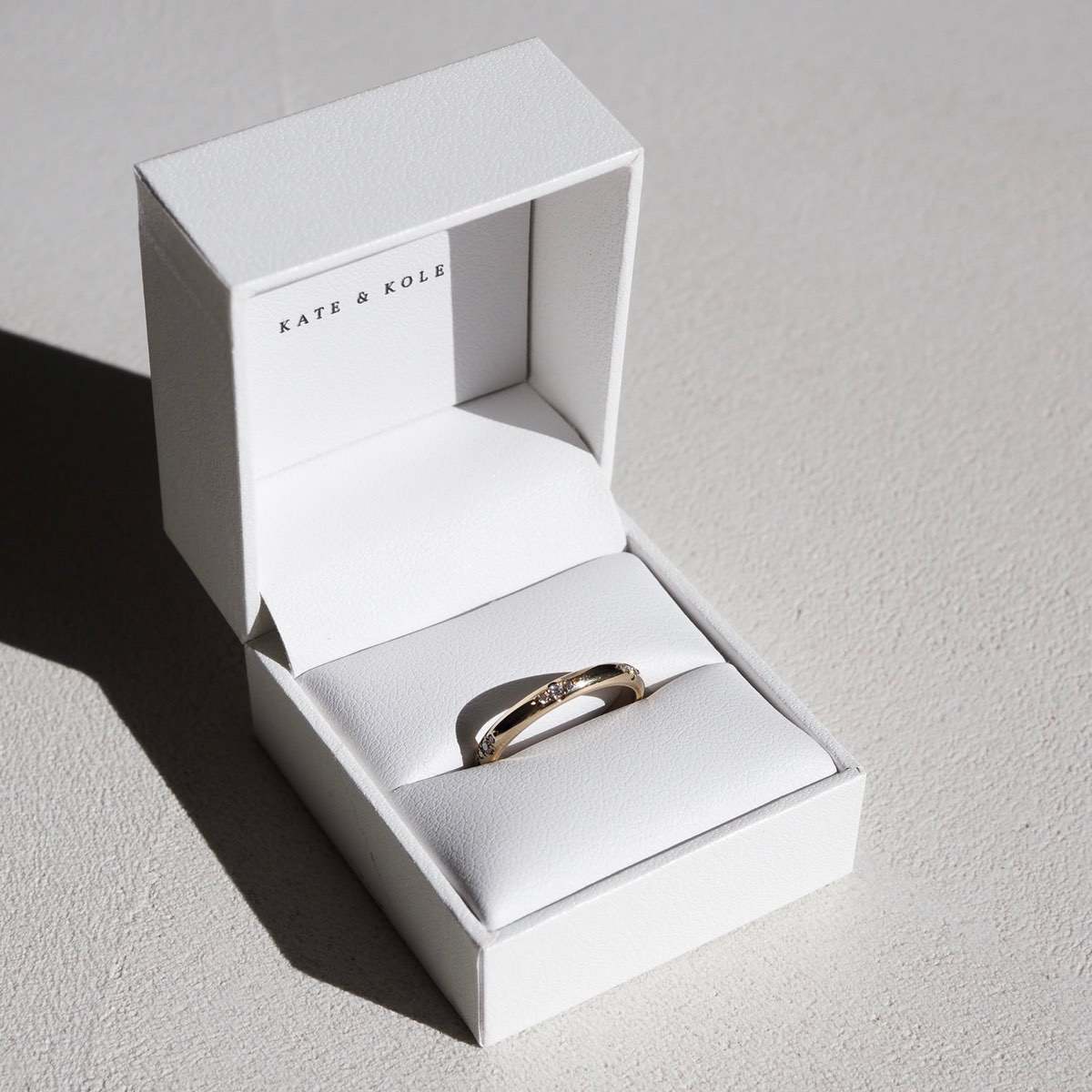 A solid gold half-round band, set with six tiny trios of speciality set lab-grown diamonds in solid 18ct yellow gold