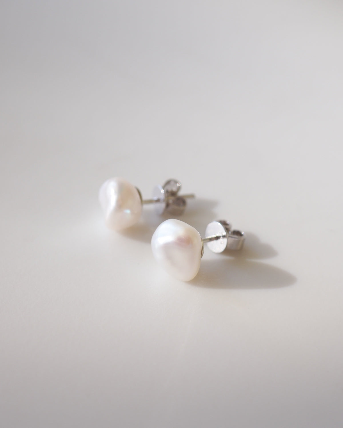 Pair of pearl earrings on a light gray background