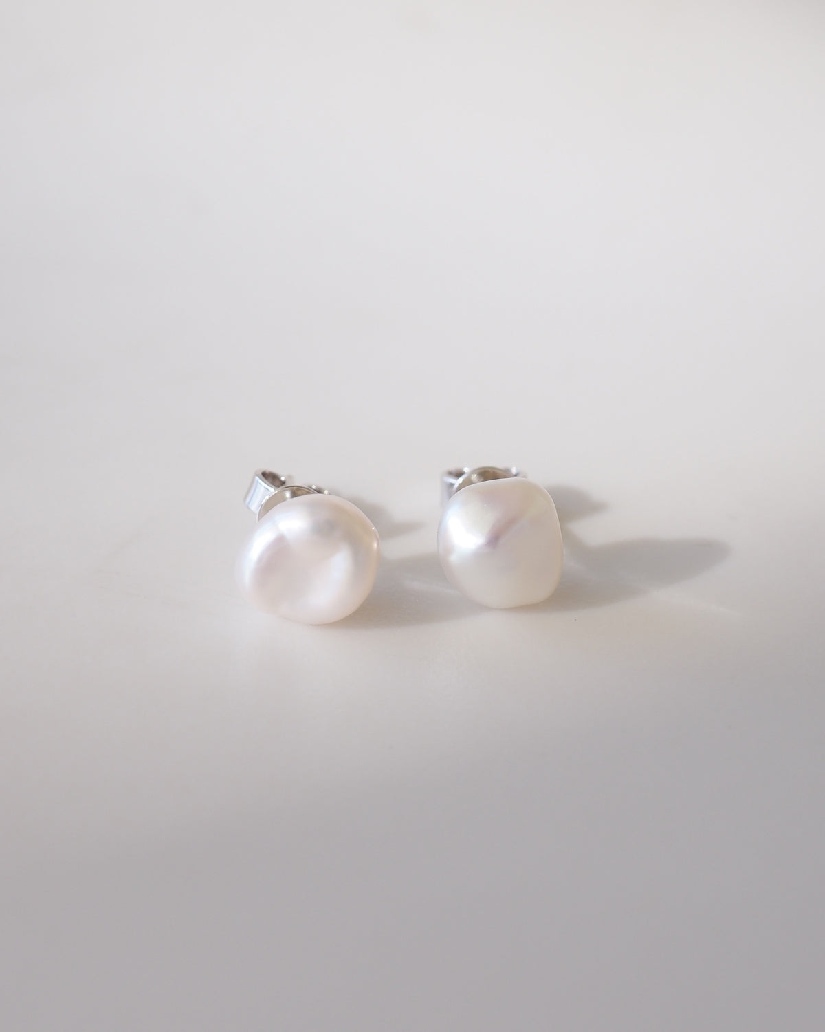 Pair of pearl earrings on a light gray background