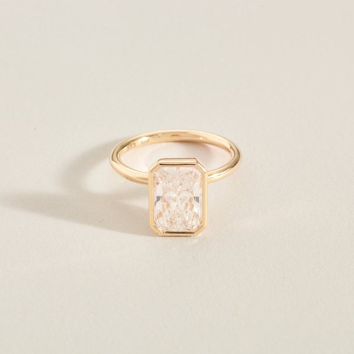 Gold diamond ring ona light beige background