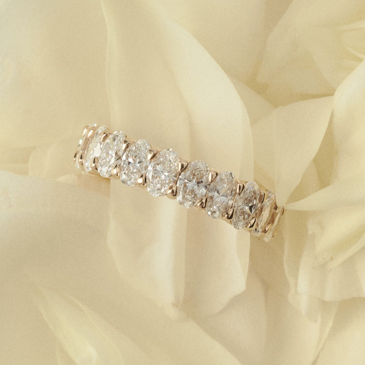 Diamond ring on a soft, light-colored fabric background