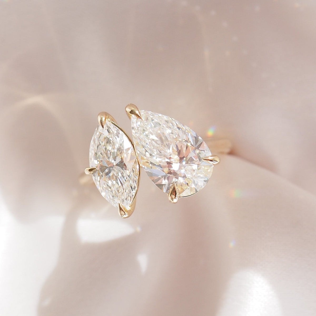 Gold-tone diamond ring showing pear and marquise stones set with prongs
