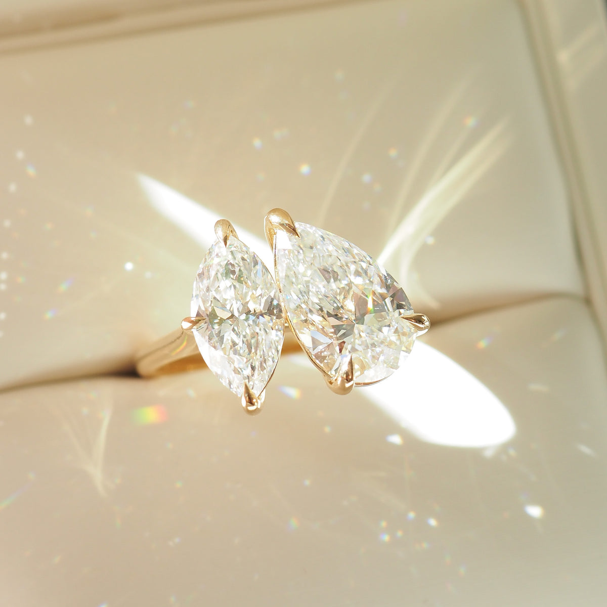 Gold-tone toi et moi diamond ring with pear and marquise stones, side angle