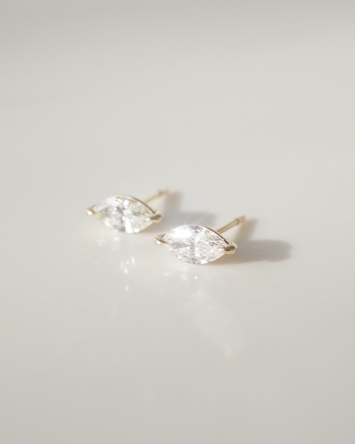 Marquise diamond stud earrings with faceted stones in gold settings