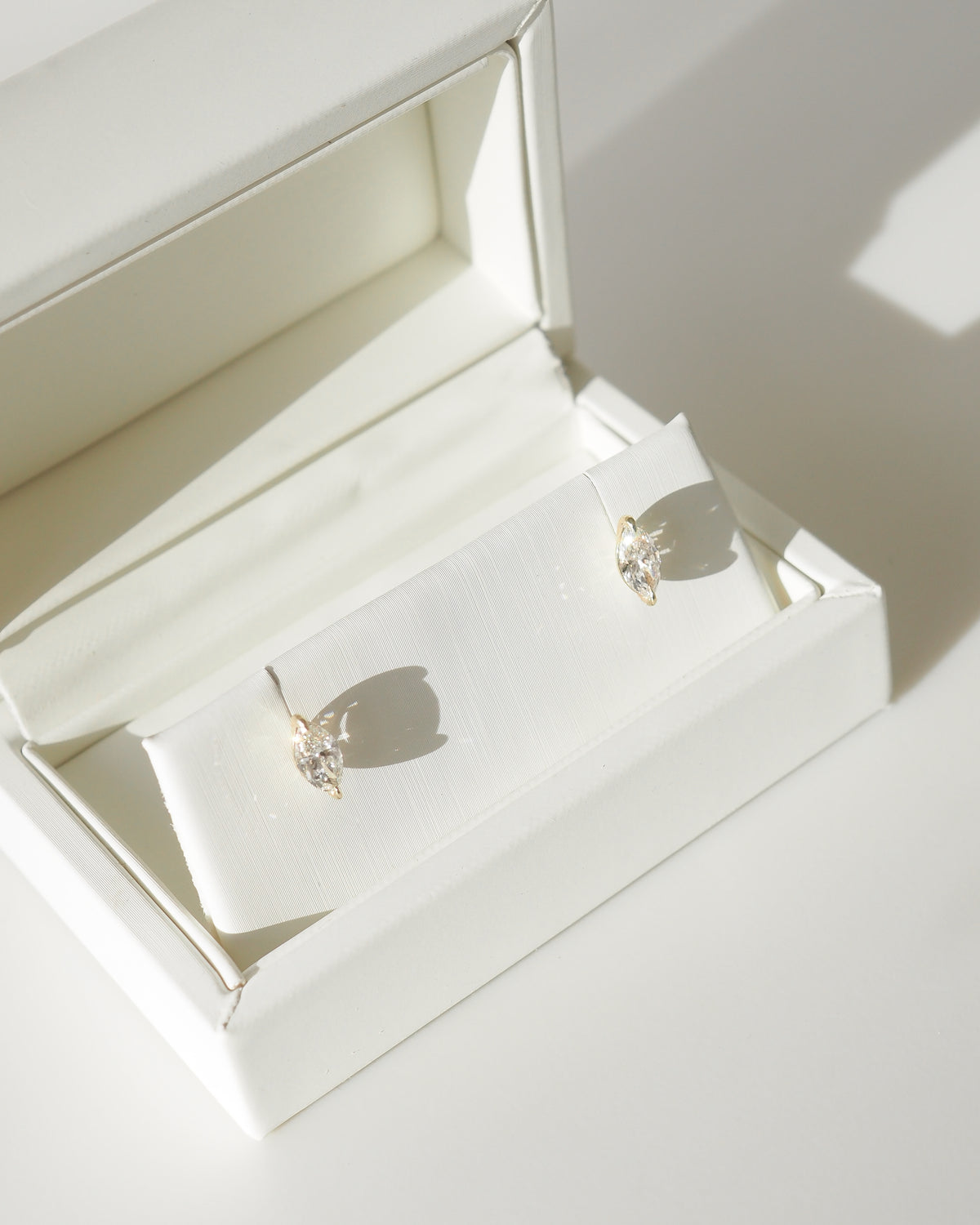 Marquise diamond stud earrings in open presentation box, pair view