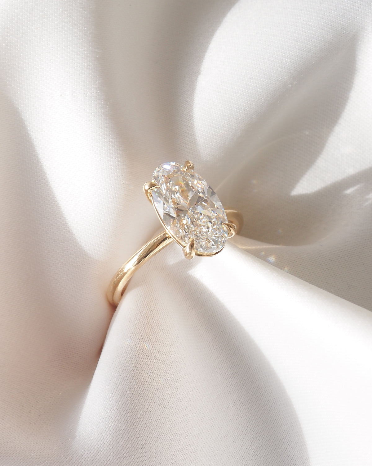 Gold oval lab-grown diamond solitaire ring with oval center stone and prongs