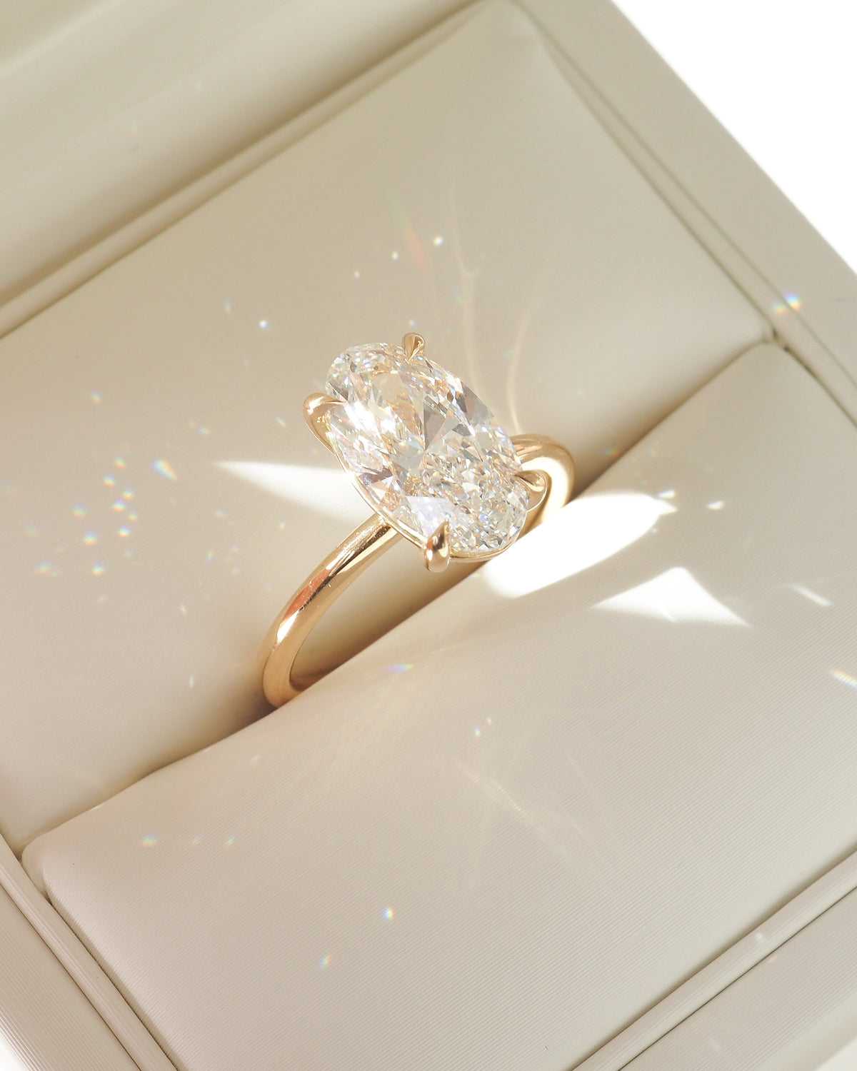 Gold oval lab-grown diamond solitaire ring with three-prong setting