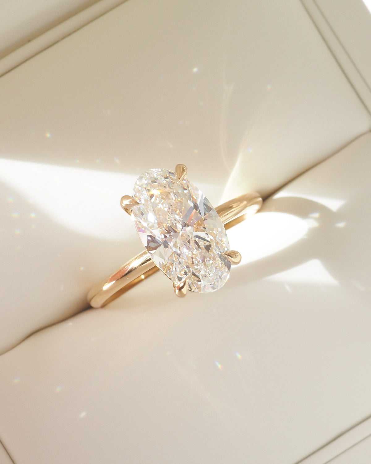 Gold oval lab-grown diamond solitaire ring, angled view with prong setting