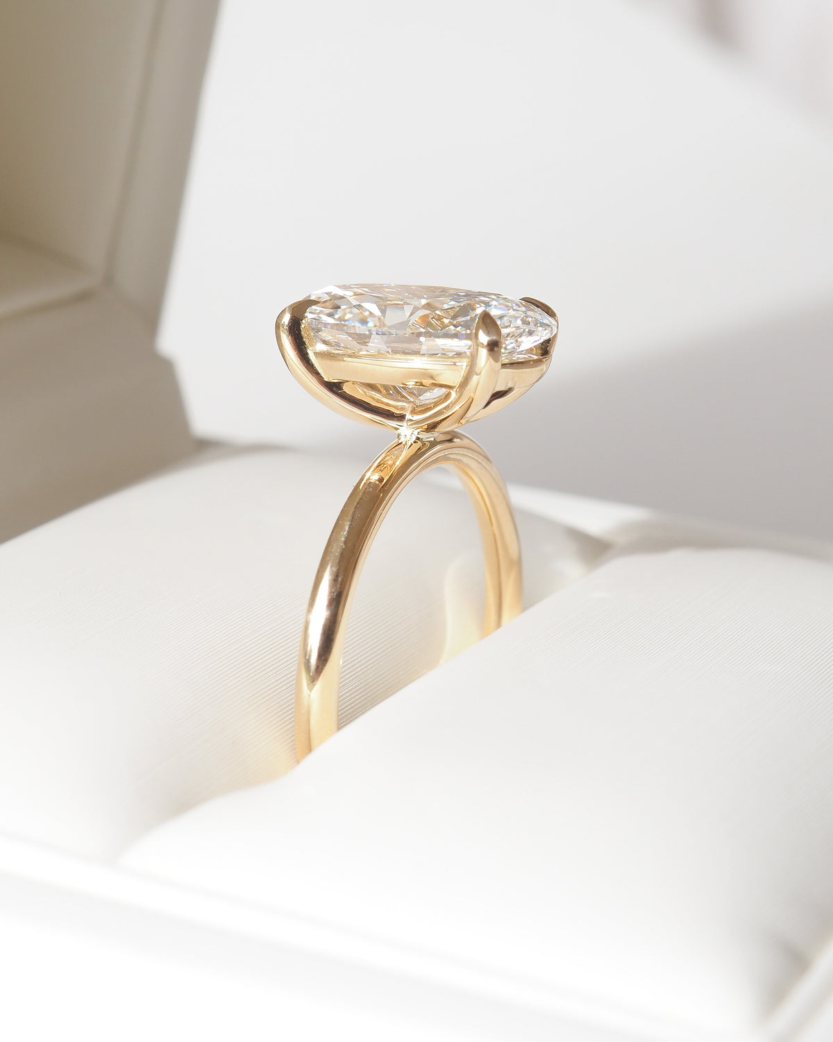 Gold oval lab-grown diamond solitaire ring, side profile showing prong setting