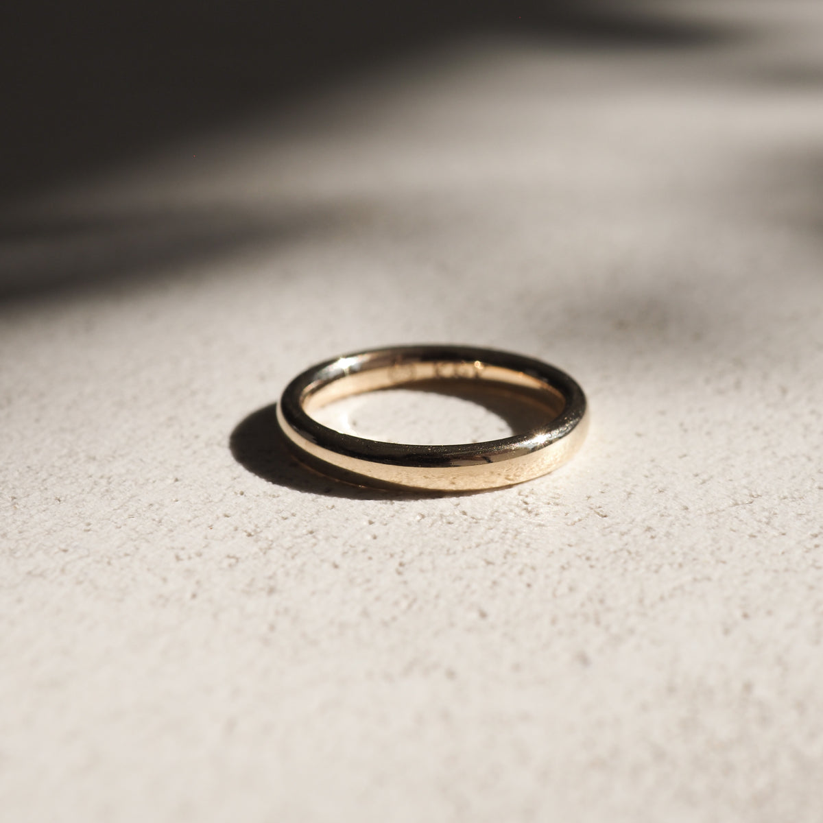 A weighted half-round band in solid 18ct yellow gold.