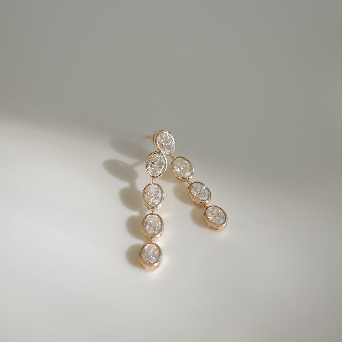 Elegant gold earrings adorned with oval diamonds, showcasing luxury jewellery design. Perfect for high-end fashion or special occasions.