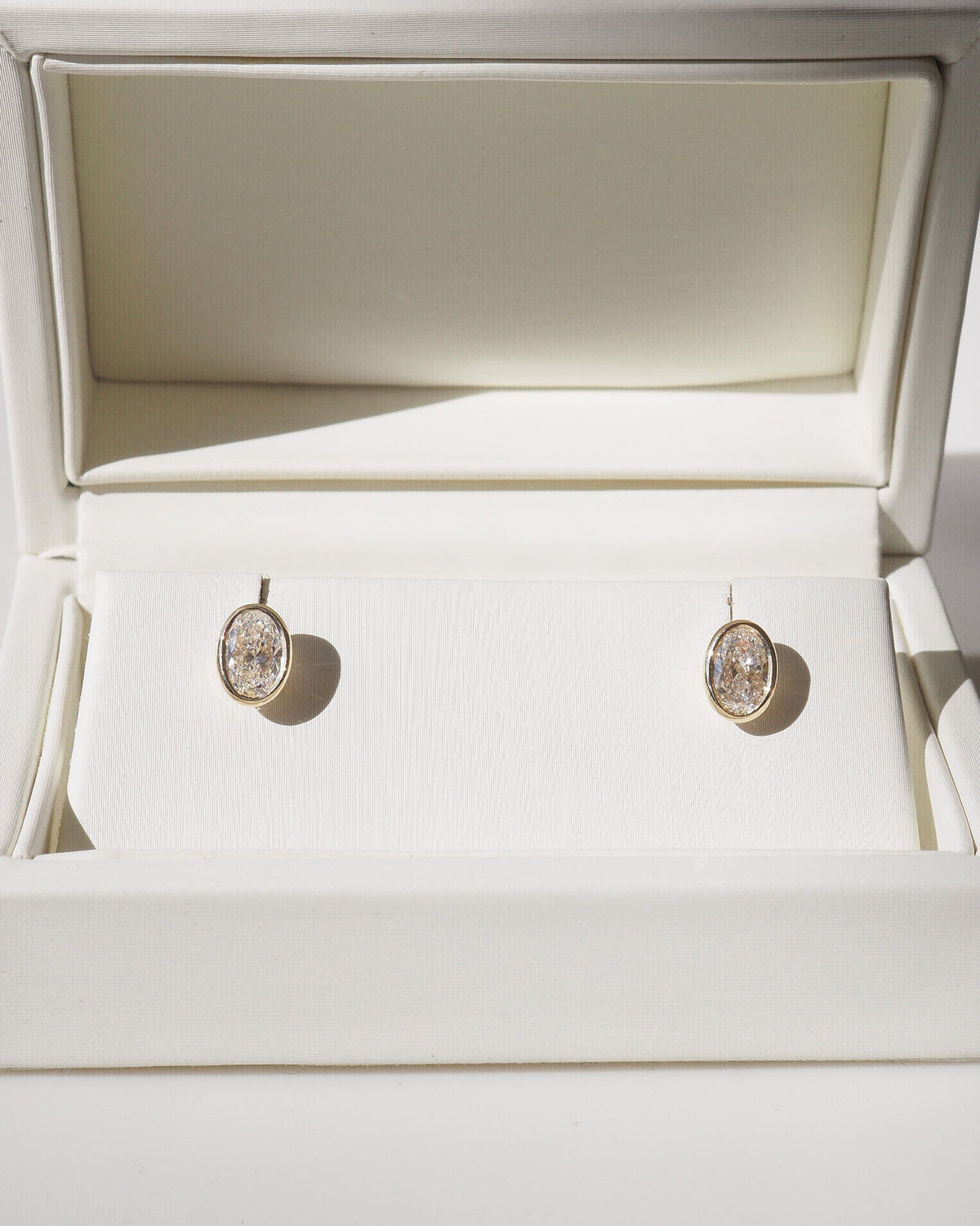 Oval bezel lab-grown diamond stud earrings, gold posts and oval bezel settings