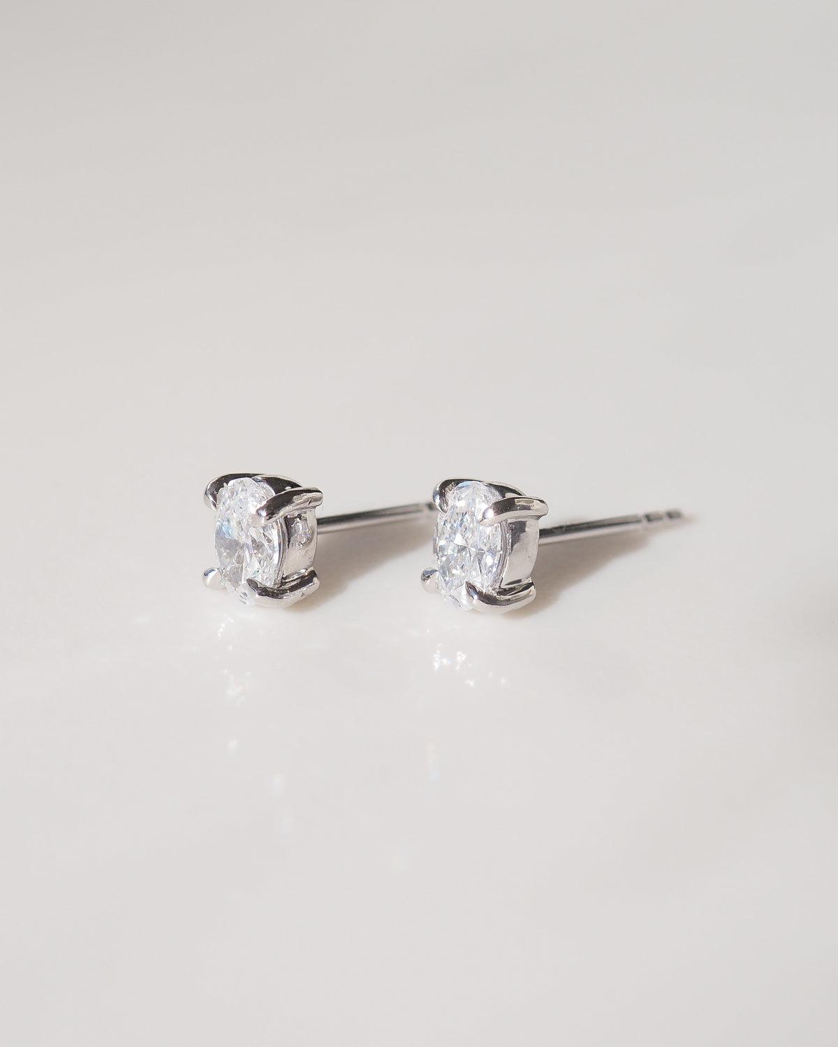 Oval gemstone stud earrings in 9ct white gold, showing metal prongs and posts