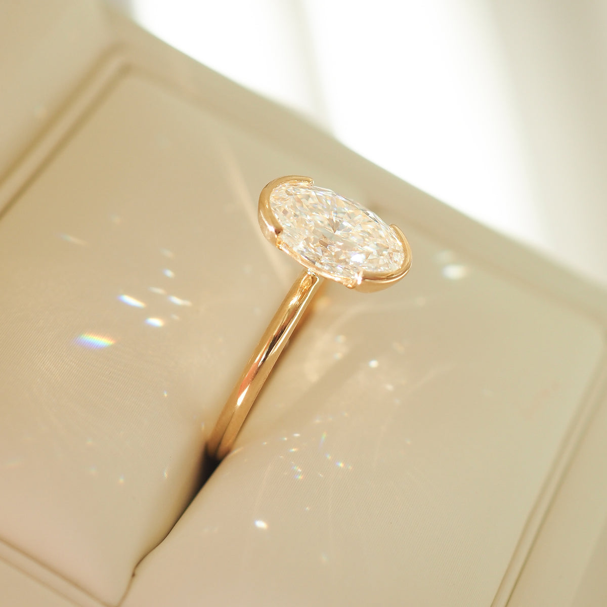 Gold oval lab-grown diamond solitaire ring with half bezel setting