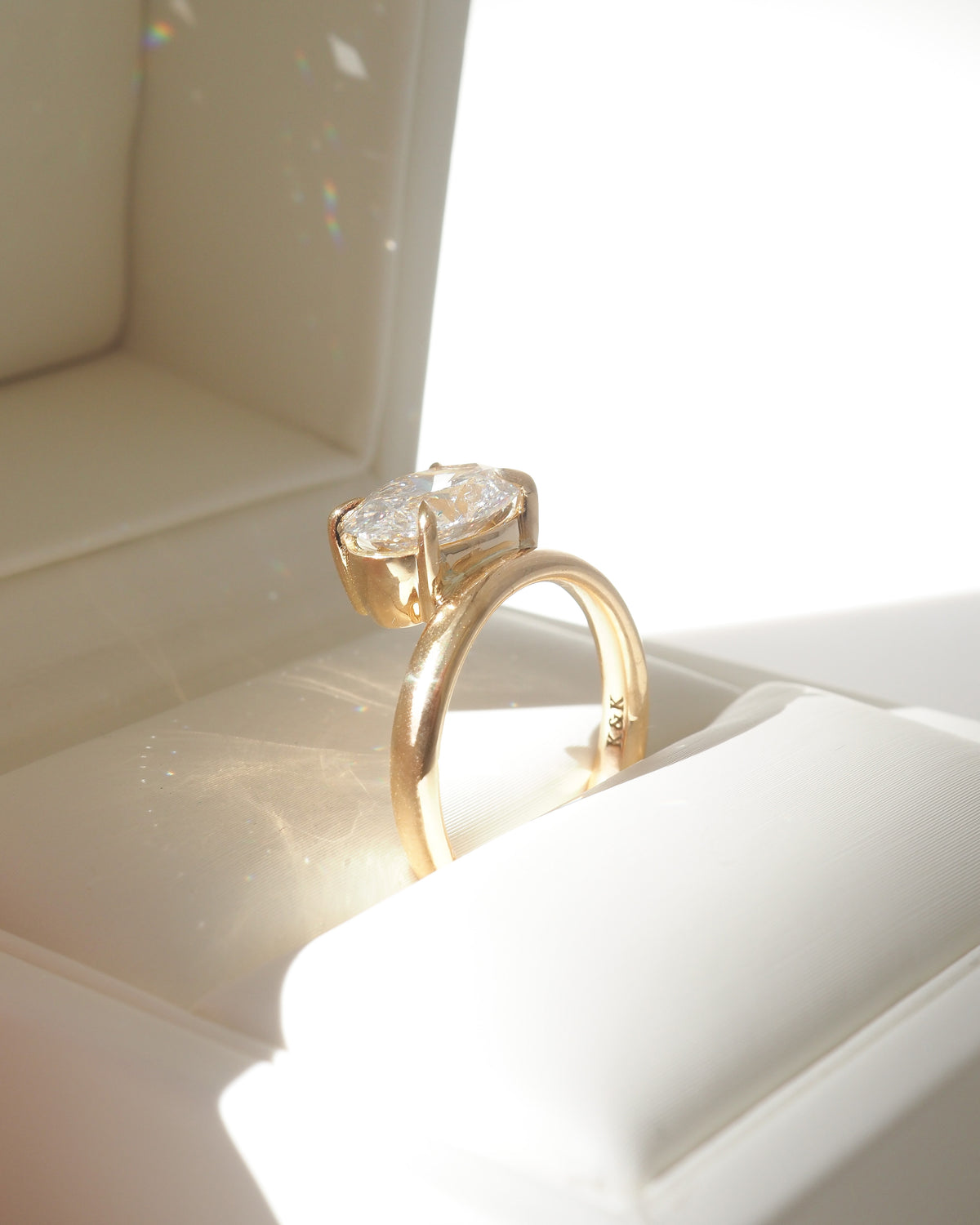 Gold solitaire ring with oval diamond center, arched band view