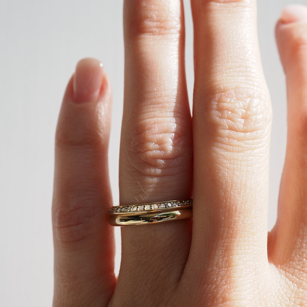 Yellow gold diamond wedding ring on finger