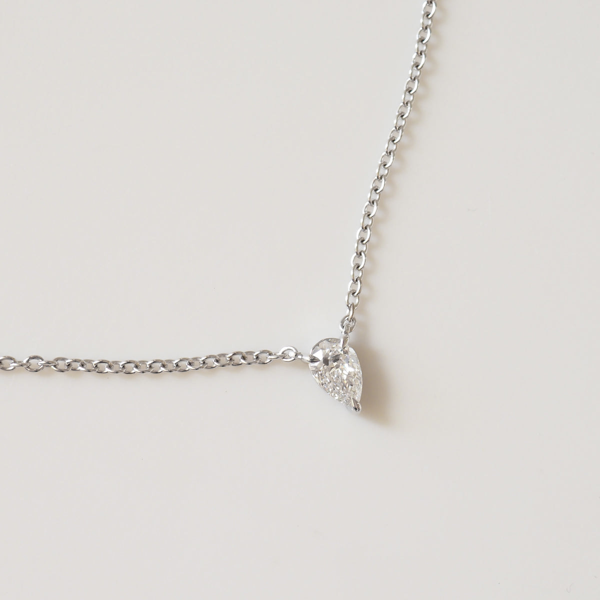 Pear diamond pendant necklace with silver chain and teardrop-cut stone