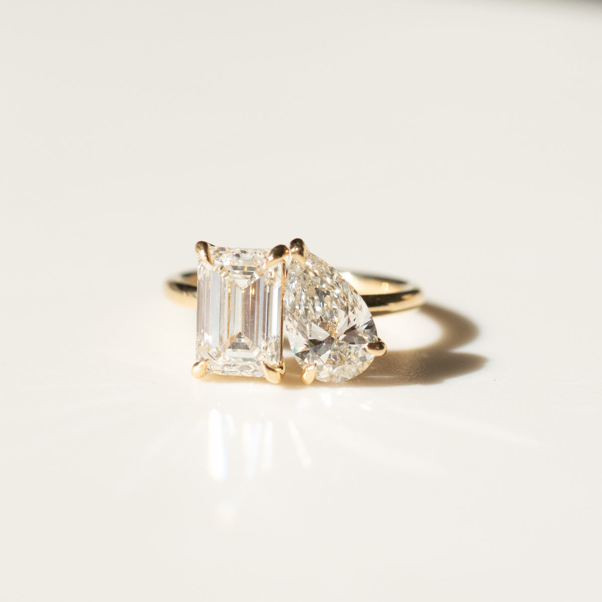 Toi et moi engagement ring, yellow gold band with emerald-cut and pear-shaped stones