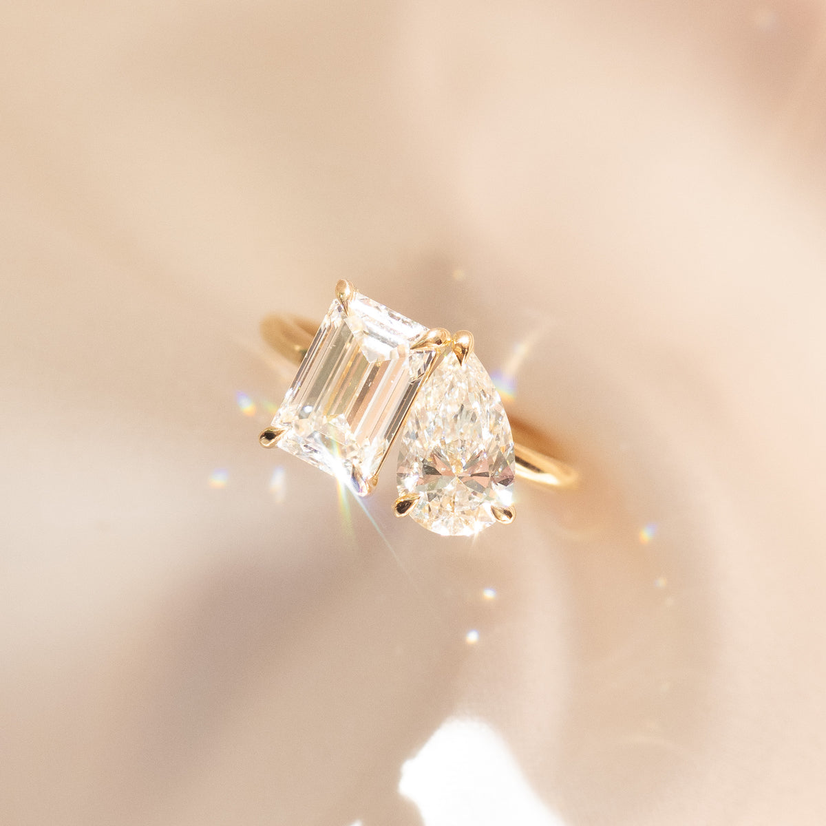 Yellow gold toi et moi engagement ring with emerald-cut and pear-shaped diamonds