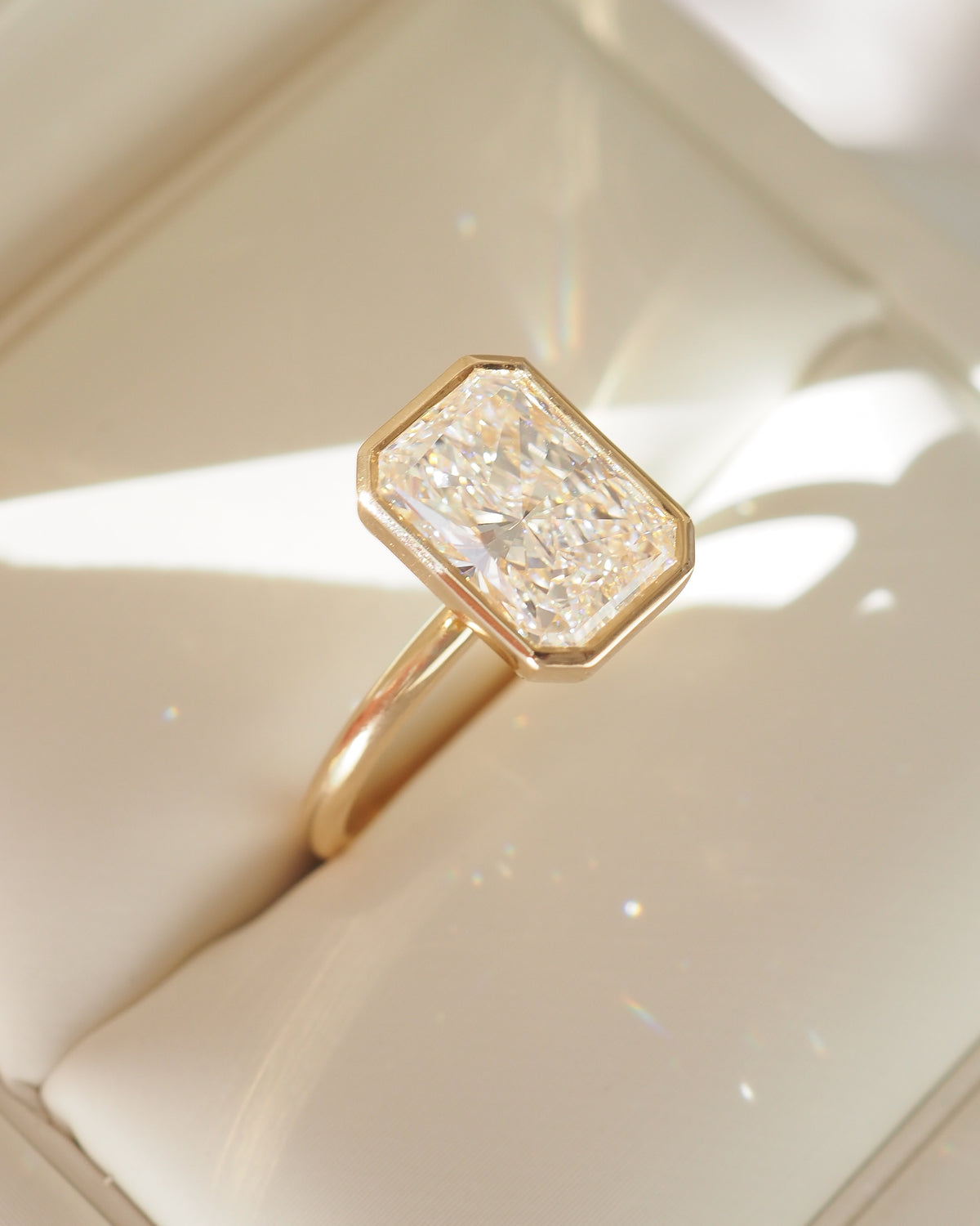 Gold radiant-cut lab-grown diamond ring with square bezel-set center stone