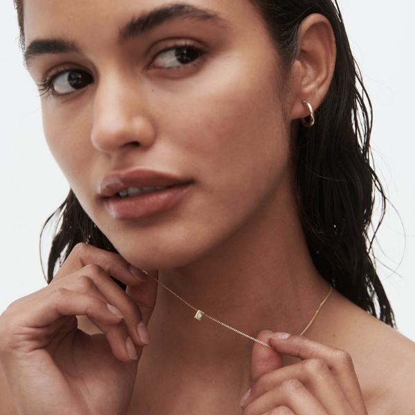 Women with gold necklace and gold hoop earrings