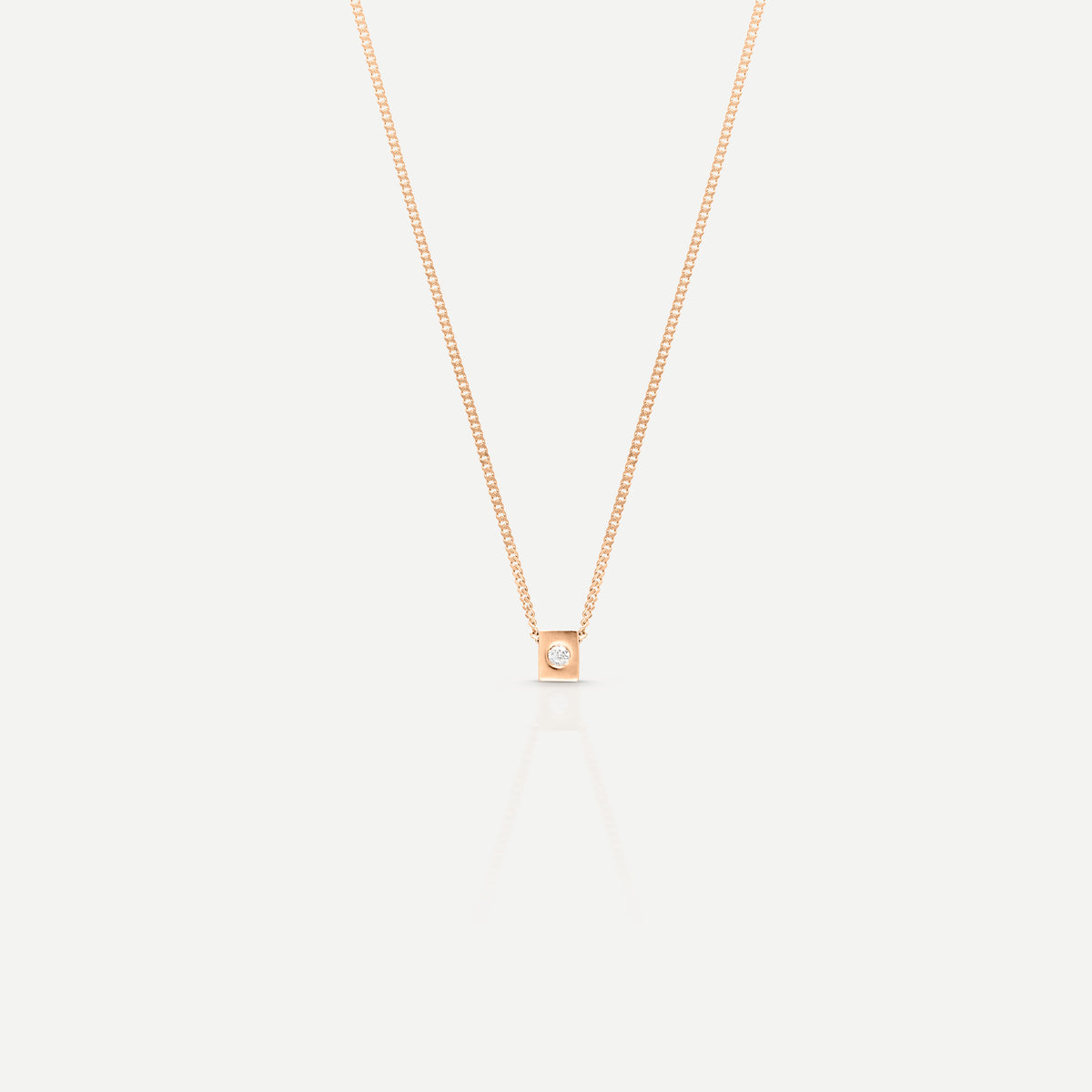 Elegant rose gold necklace with a single diamond pendant on a light background, showcasing minimalist luxury jewellery design.
