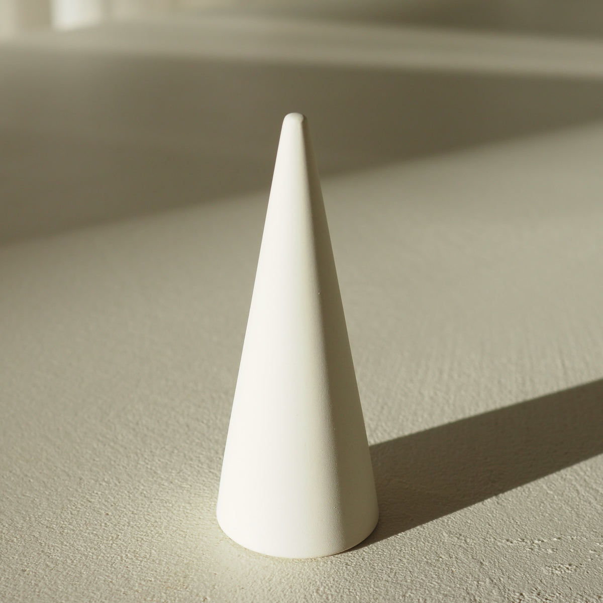 White ring sizer on a textured beige surface