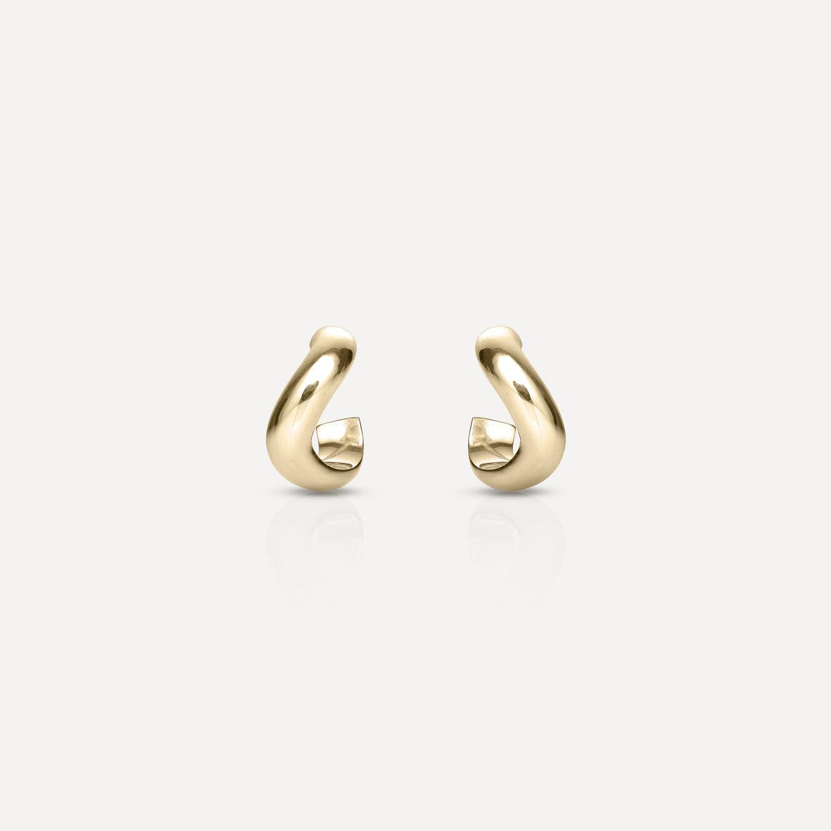 Gold hoop earrings with a modern, curved design on a white background. Simple luxury jewellery piece.