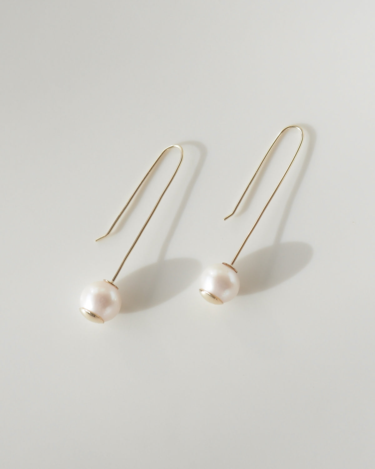 Pearl earrings on a light gray background
